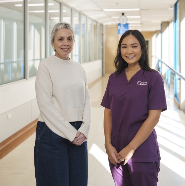 A McGrath Cancer Care Nurse standing with a patient in a hospital corridor