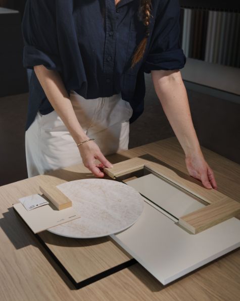 Comparing polytec door, benchtop and stone samples on a table